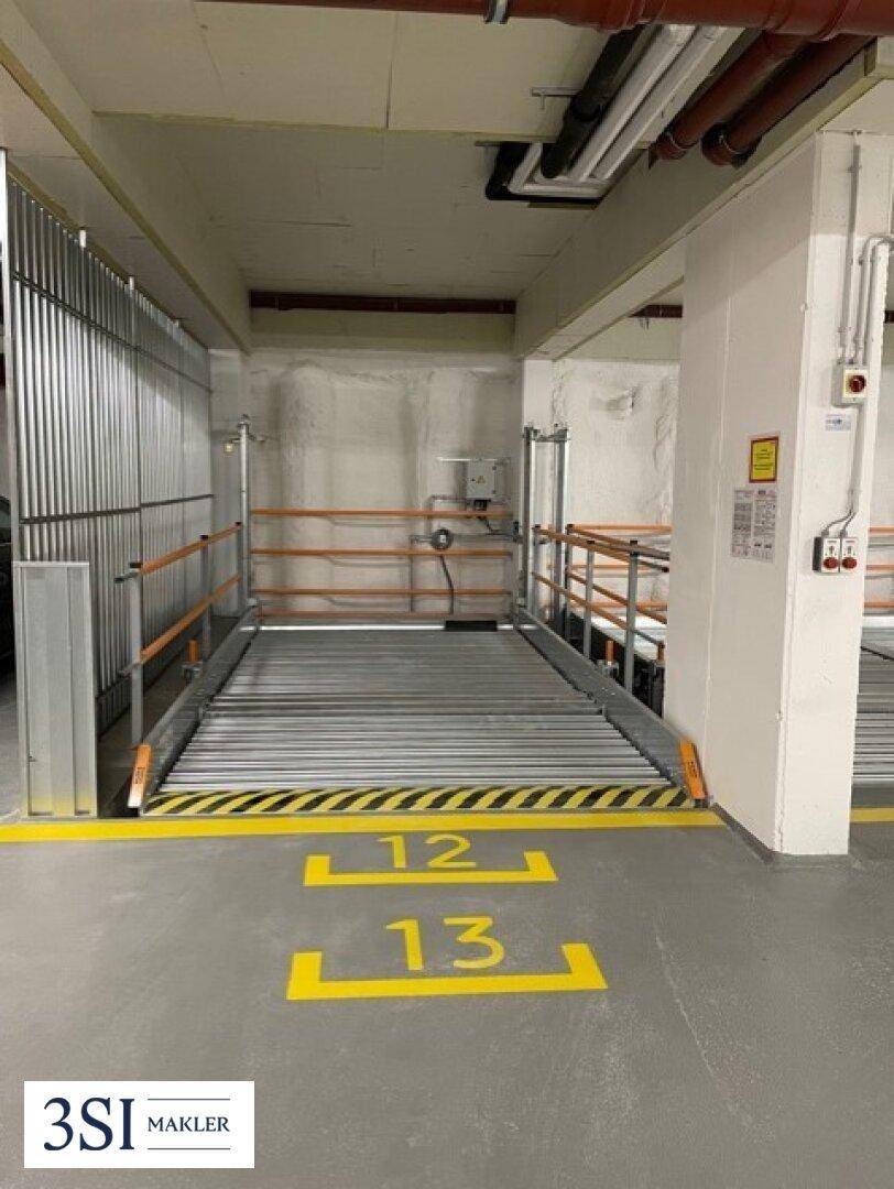 Tiefgarage mit mechanischem Parksystem für zwei Fahrzeuge und nummerierten Stellplätzen.