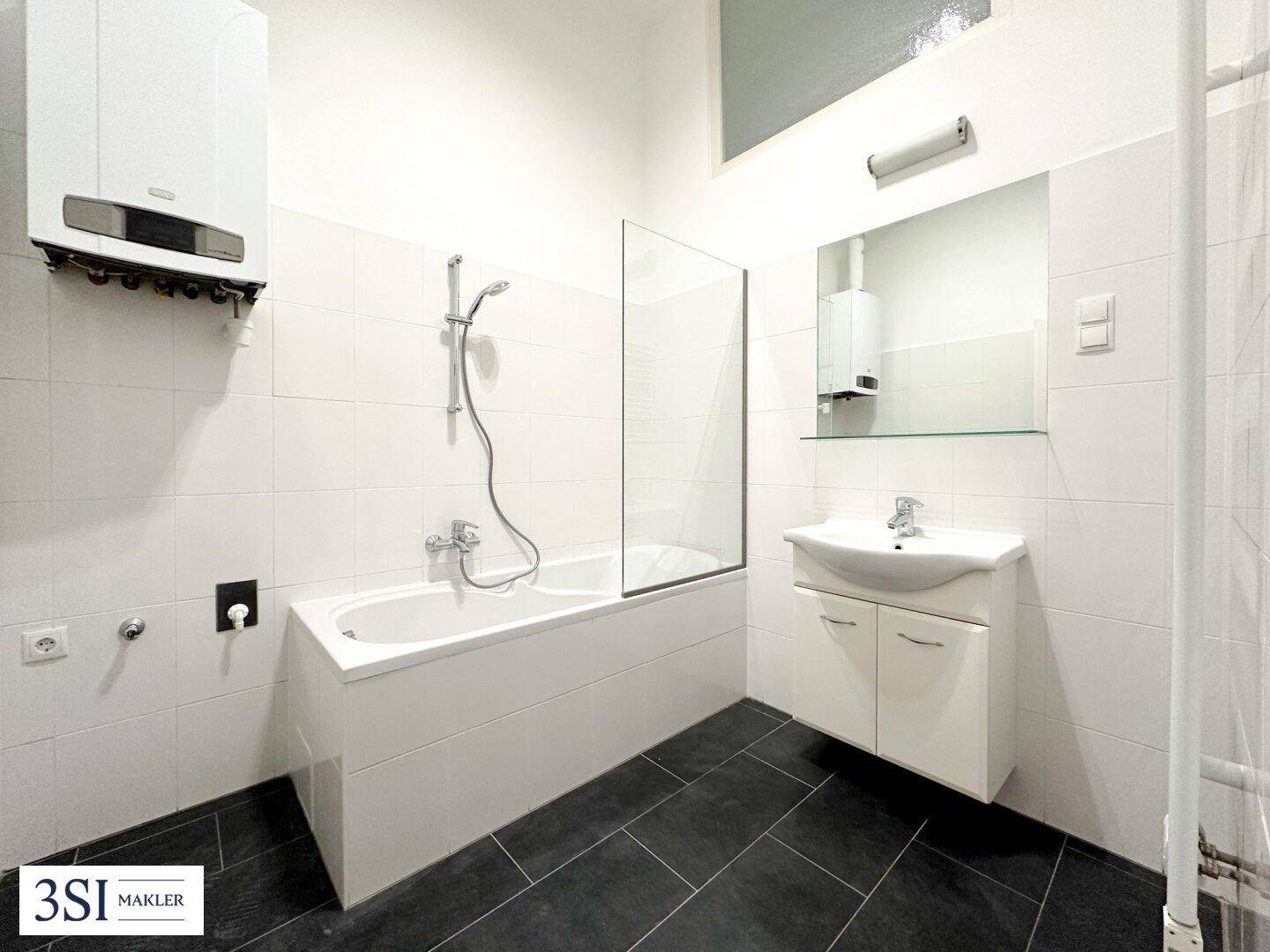 Helles Badezimmer mit Badewanne, Duschfunktion, Wandheizung und modernen Fliesen.