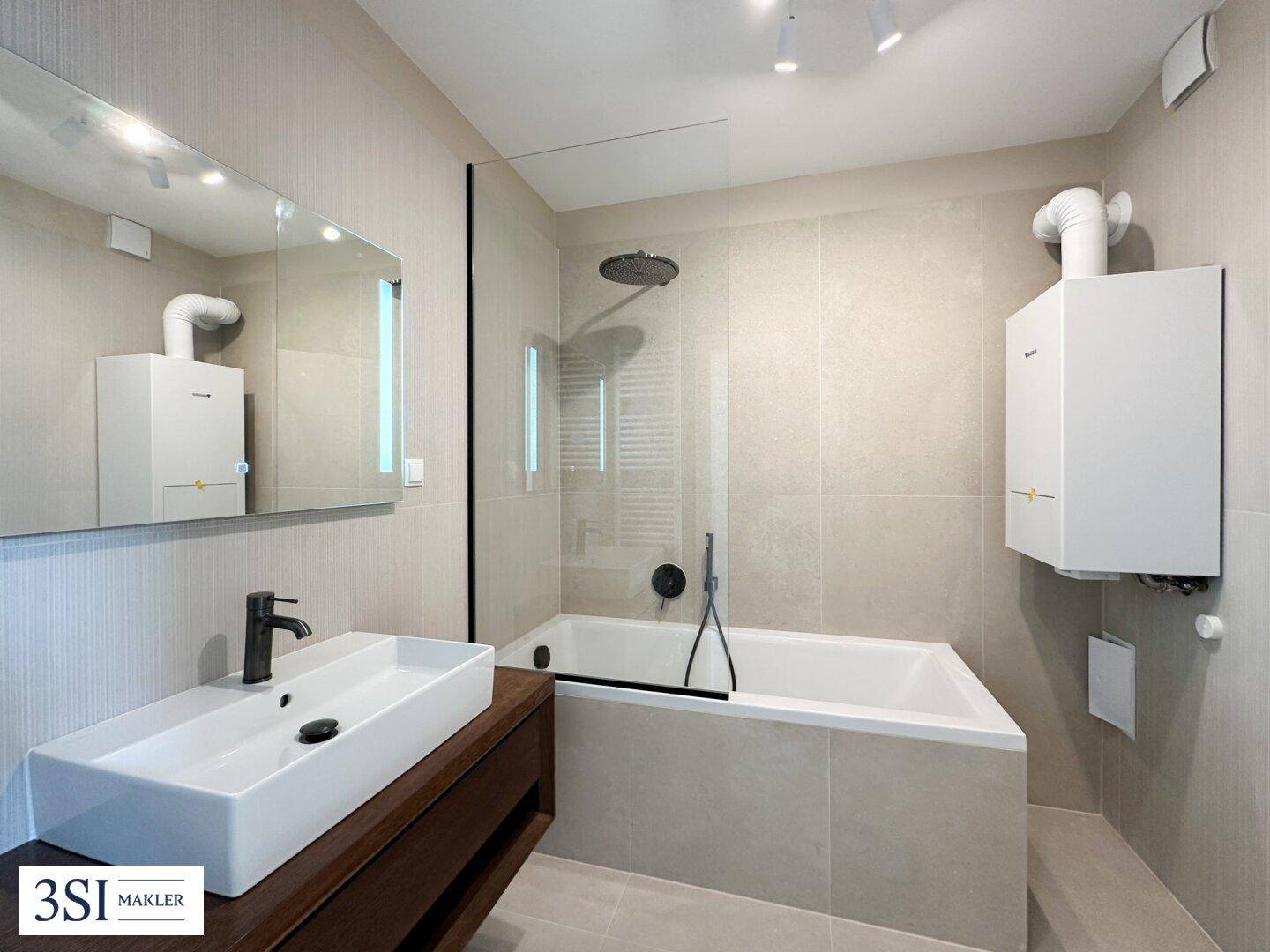 Funktionales Badezimmer mit Badewanne, Dusche und Gastherme an der Wand, in neutralen Farbtönen gehalten.