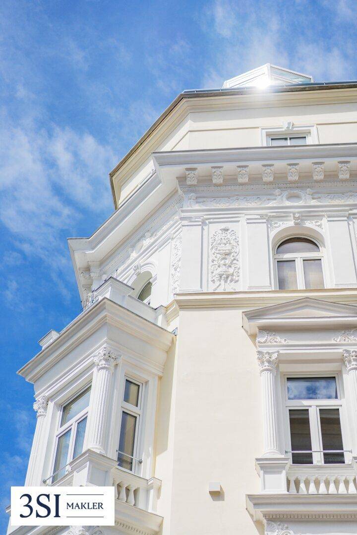 Nahaufnahme der reich verzierten Fassade eines historischen Gebäudes mit Erker und klassischen Details.