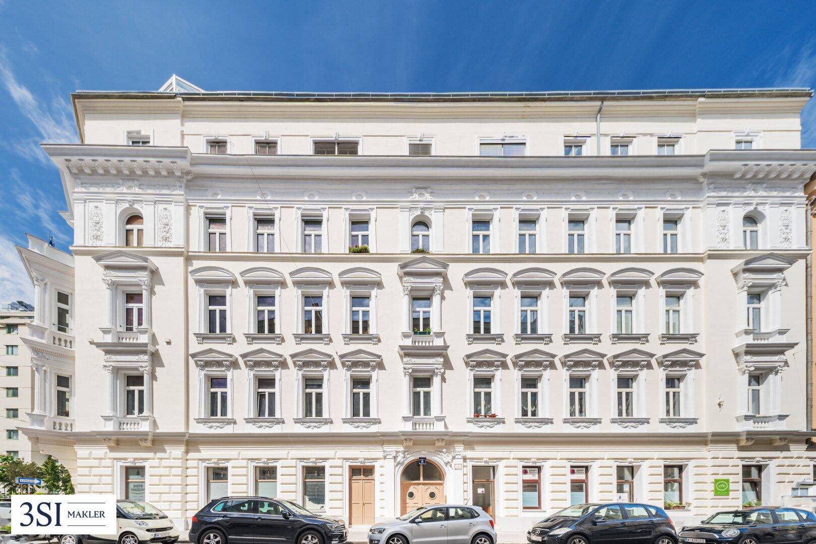 Elegante Fassade eines historischen Gebäudes mit vielen Fenstern und dekorativen Elementen, gut erhalten.
