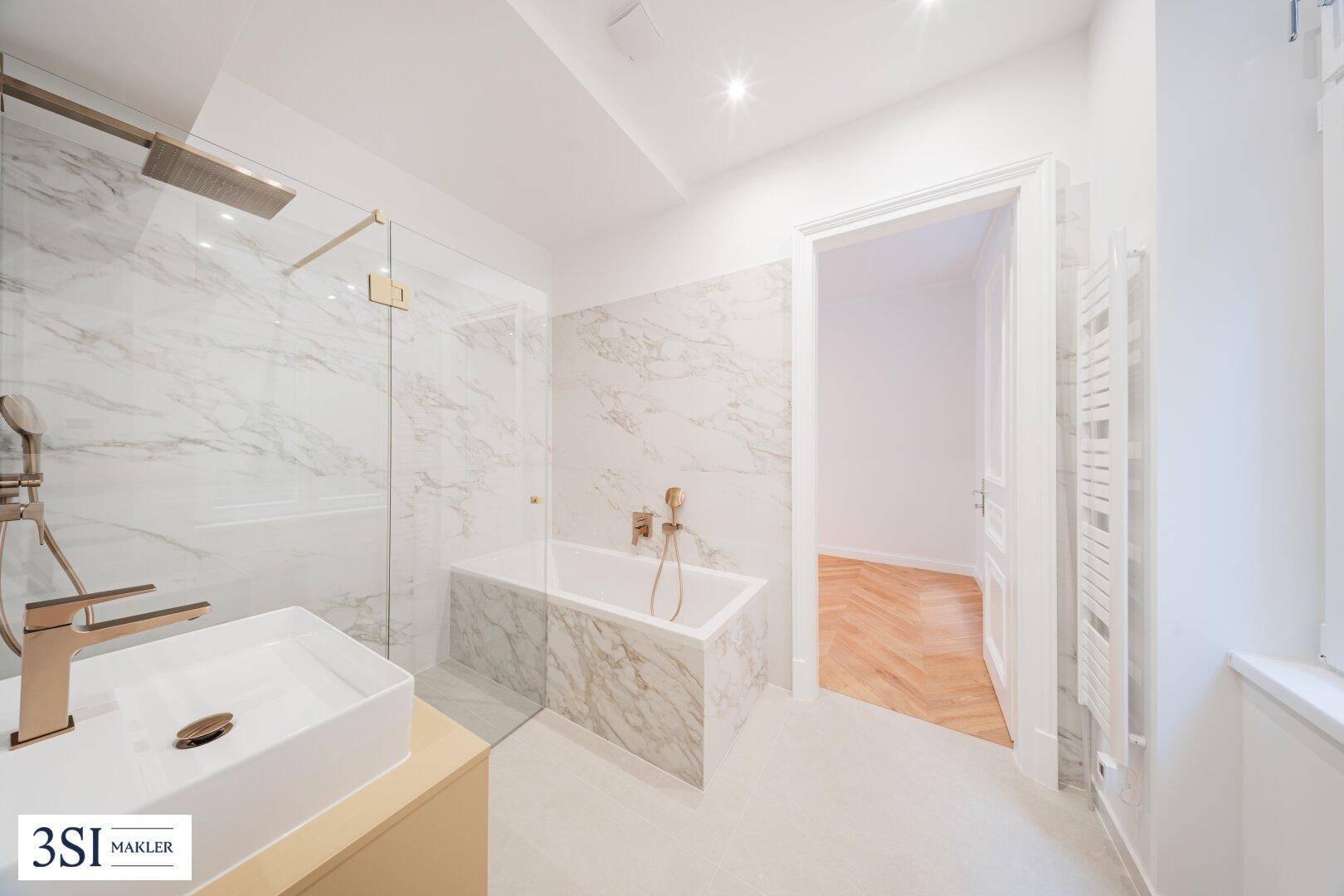 Elegantes Badezimmer mit goldfarbenen Armaturen, begehbarer Dusche und integrierter Badewanne.