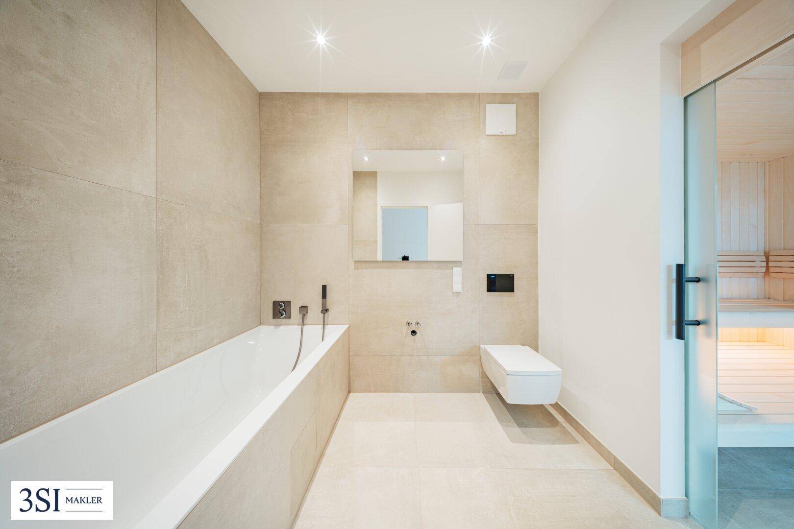 Modernes Badezimmer mit Badewanne, Wand-WC und direktem Zugang zu einer Sauna.