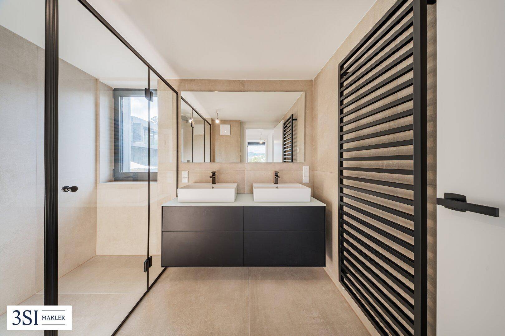 Elegantes Badezimmer mit Doppelwaschbecken, großem Spiegel und beheiztem Handtuchhalter.