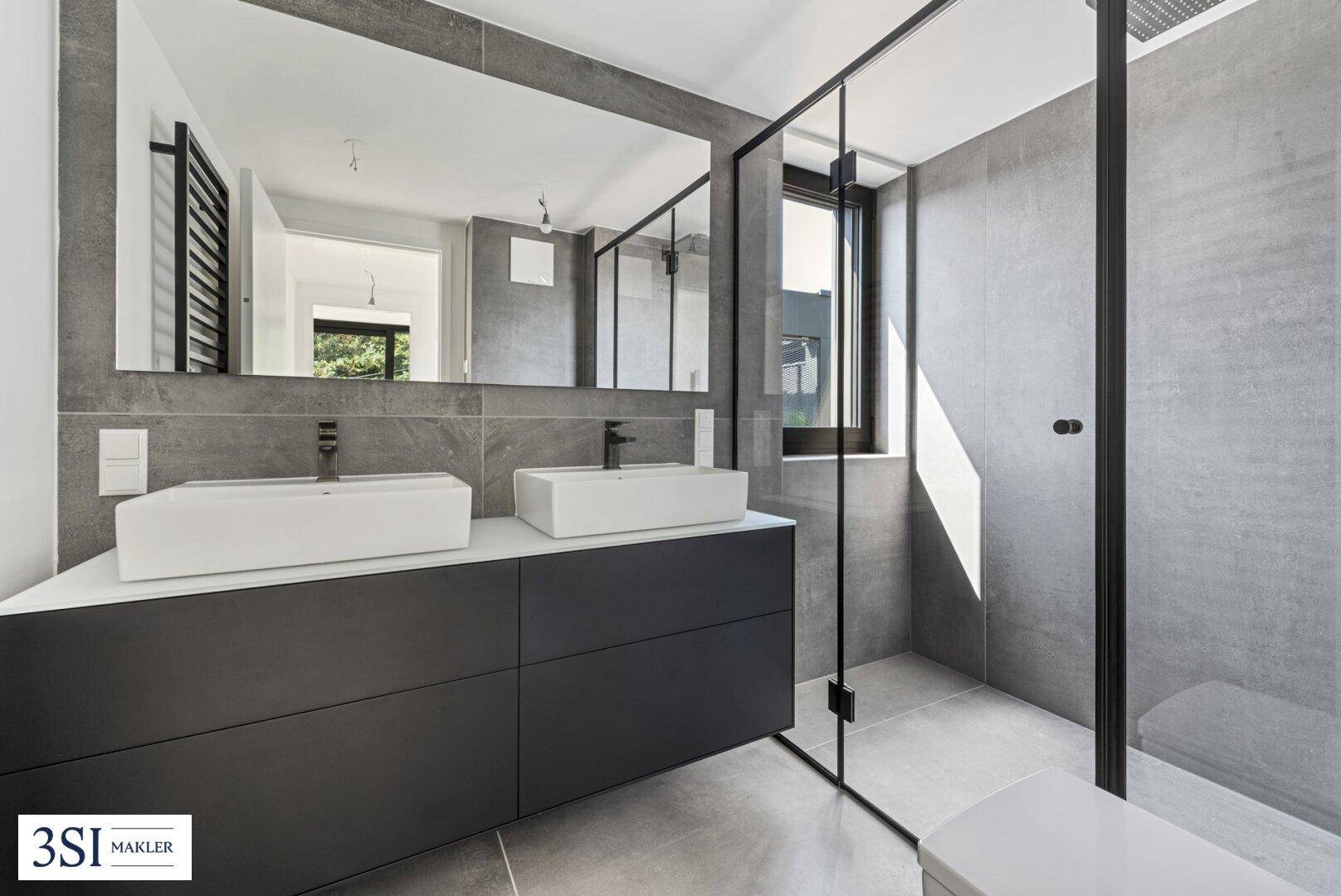 Modernes Badezimmer mit Doppelwaschbecken, großem Spiegel und begehbarer Dusche in Grautönen.