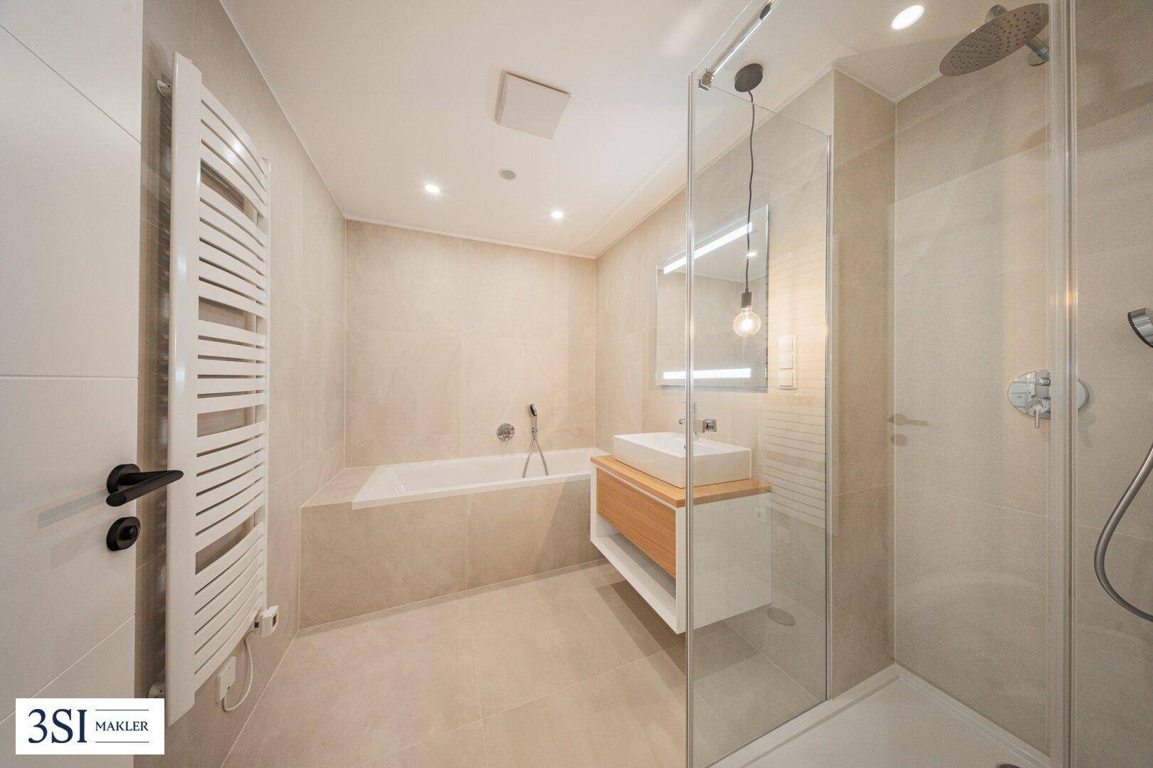 Modernes Badezimmer mit Badewanne, begehbarer Dusche, Einzelwaschbecken und beheiztem Handtuchhalter.