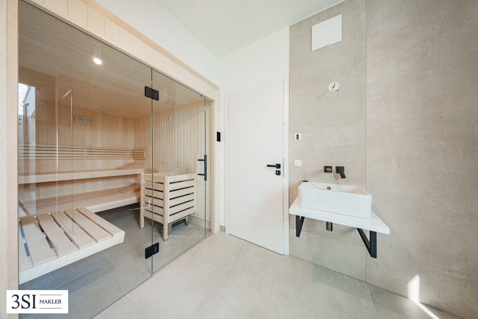 Moderner Wellnessbereich mit Sauna und minimalistischem Waschbecken.