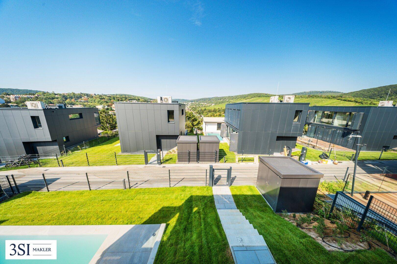 Überblick über die moderne Siedlung mit mehreren Villen und grüner Umgebung.