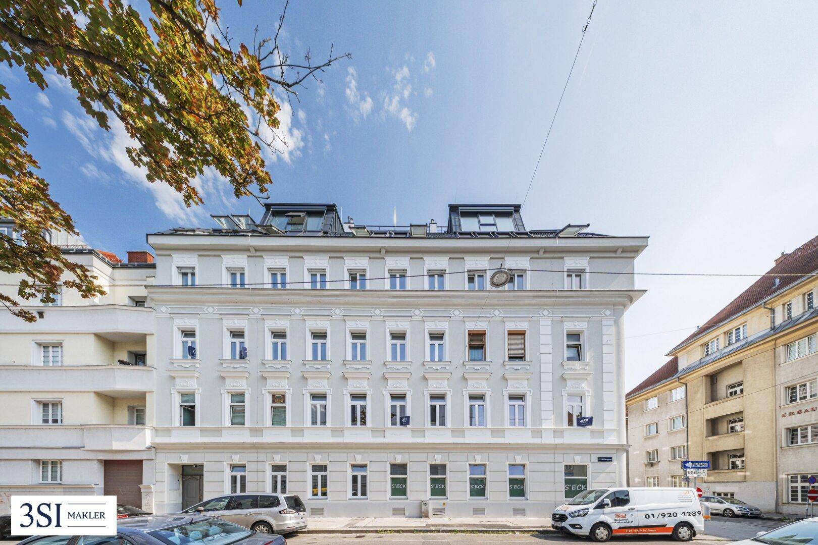 Klassische Fassade eines Mehrfamilienhauses mit vielen Fenstern und gepflegtem Erscheinungsbild.