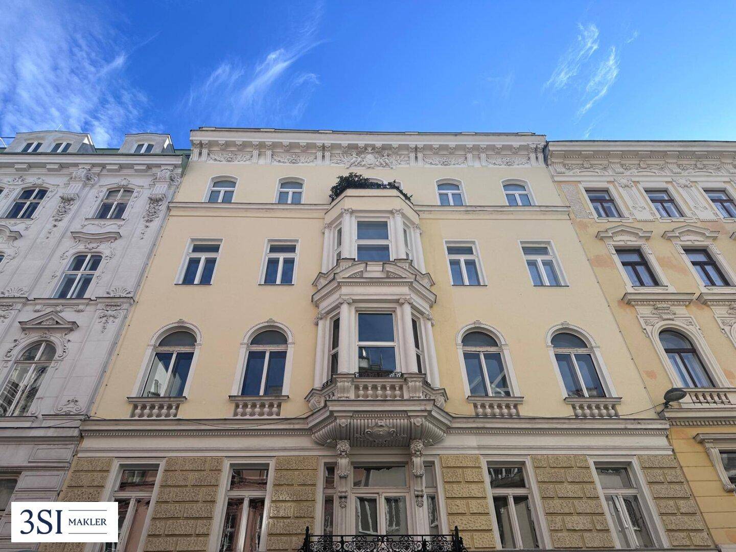 Historische Fassade eines Altbaus mit eleganten Verzierungen und charakteristischen Erkern.