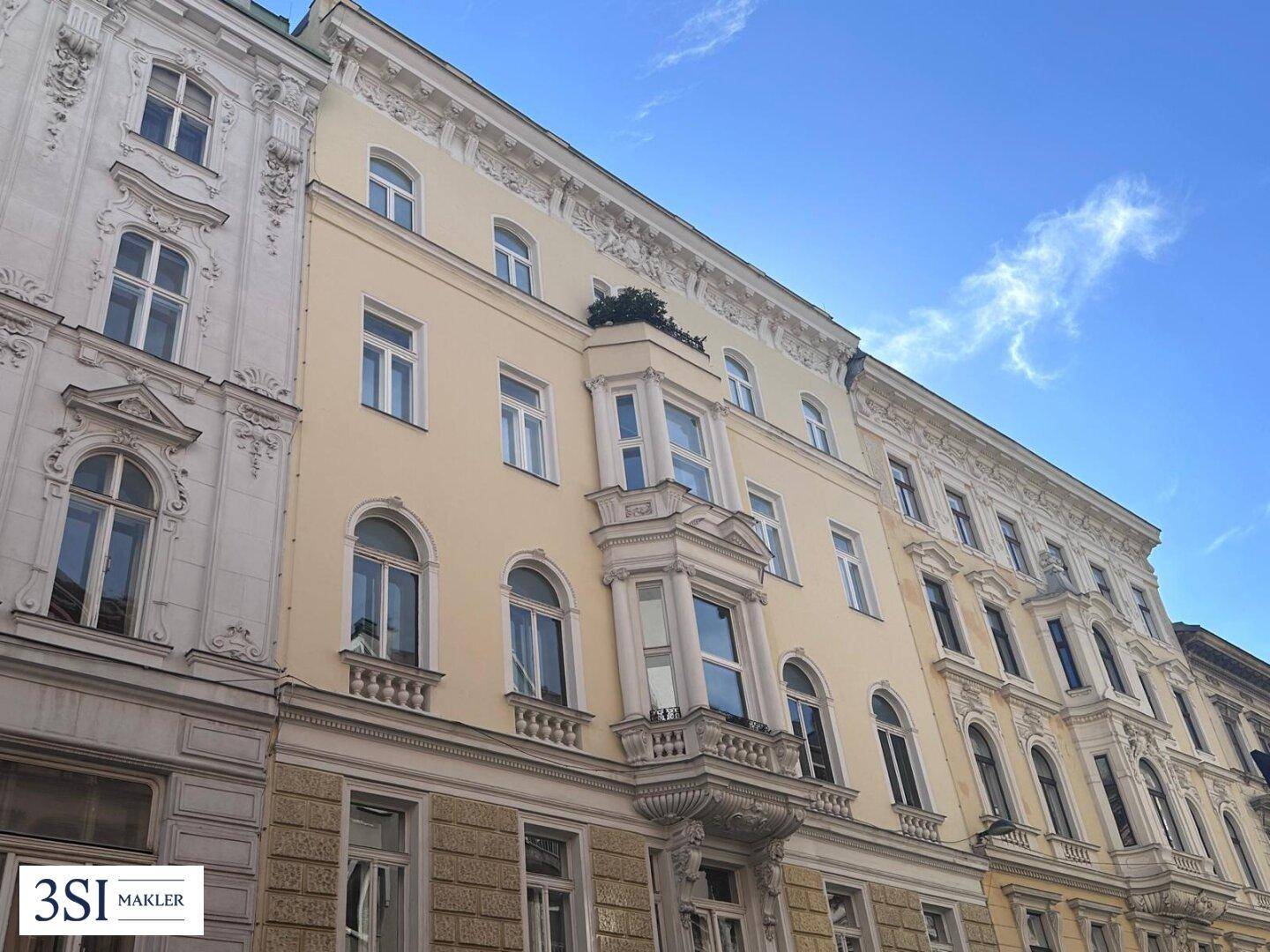 Historische Fassade eines Altbaus mit eleganten Verzierungen und charakteristischen Erkern.
