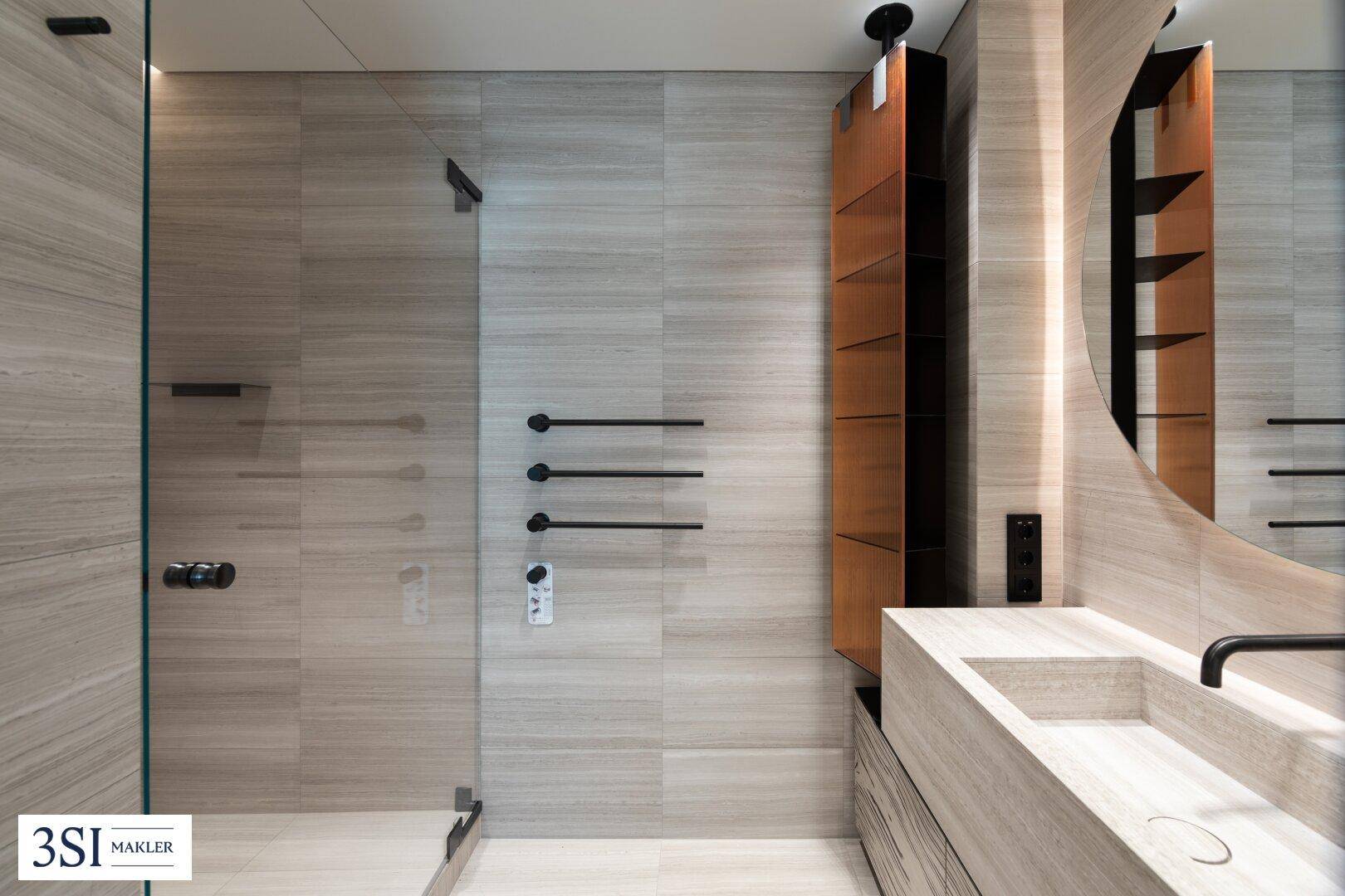 Modernes Badezimmer mit begehbarer Dusche, eleganten Fliesen und stilvollem Waschtisch.