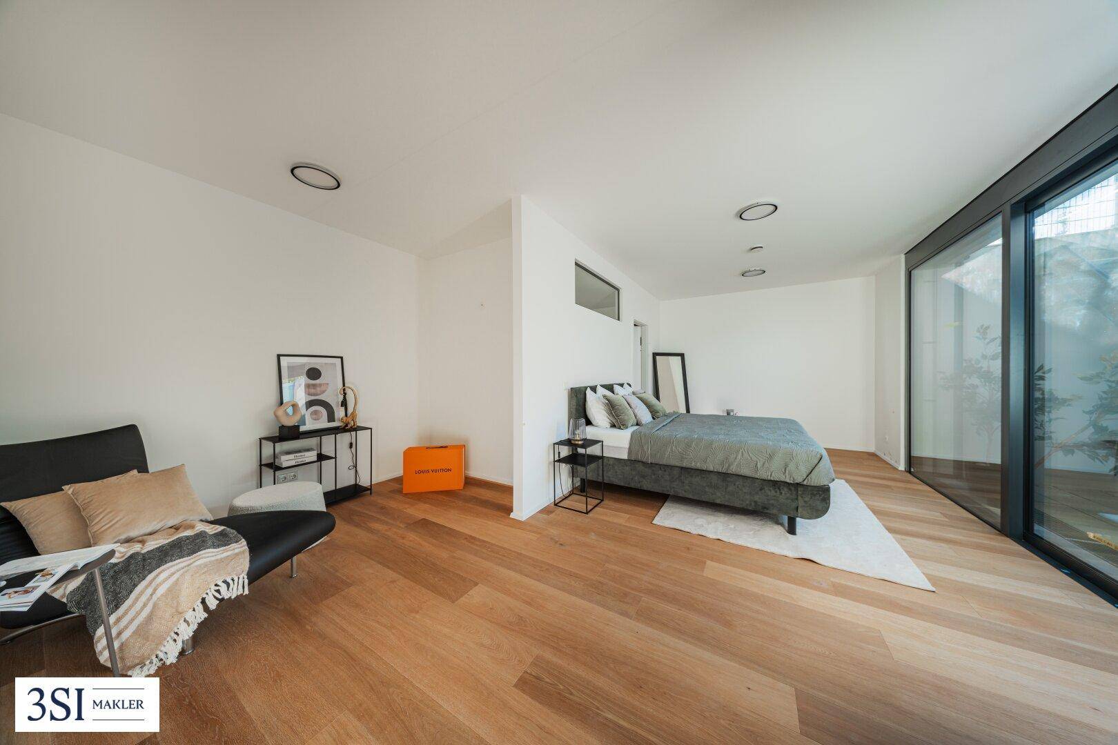 Helles Schlafzimmer mit Holzboden, modernem Bett und minimalistischer Einrichtung.