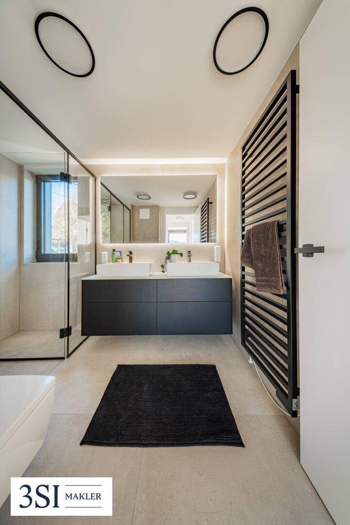 Elegantes Badezimmer mit Doppelwaschbecken, großer Spiegelfläche und begehbarer Dusche.