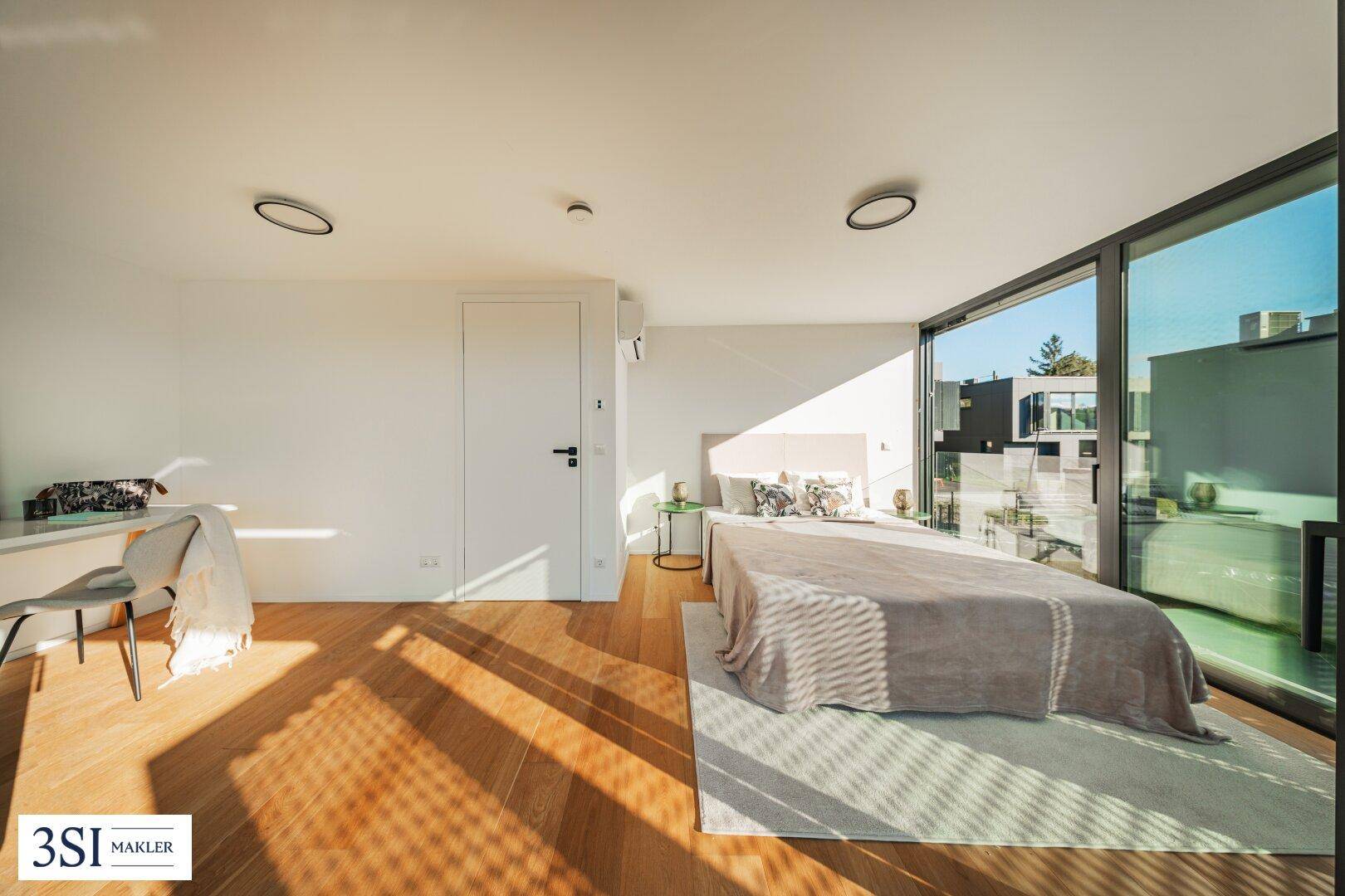 Helles Schlafzimmer mit Holzboden, großen Fenstern und viel natürlichem Licht.