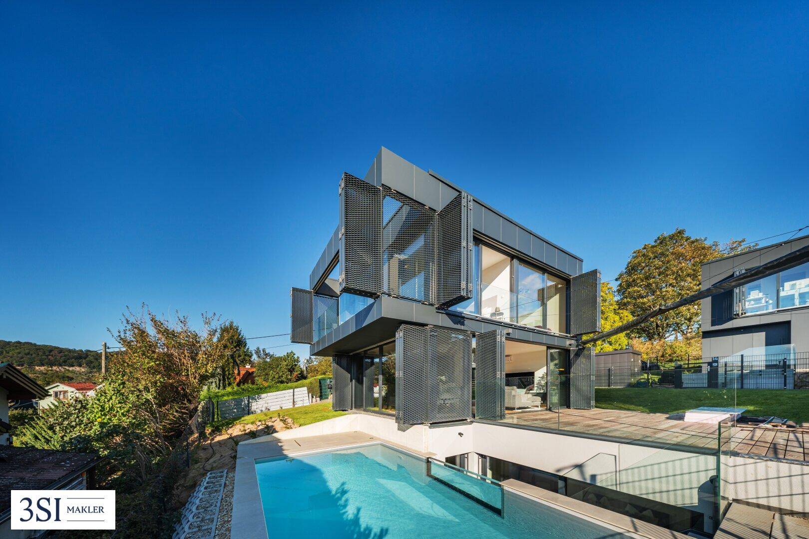 Moderne Architektur mit großen Glasflächen, innovativen Fassadenelementen und einem Außenpool.