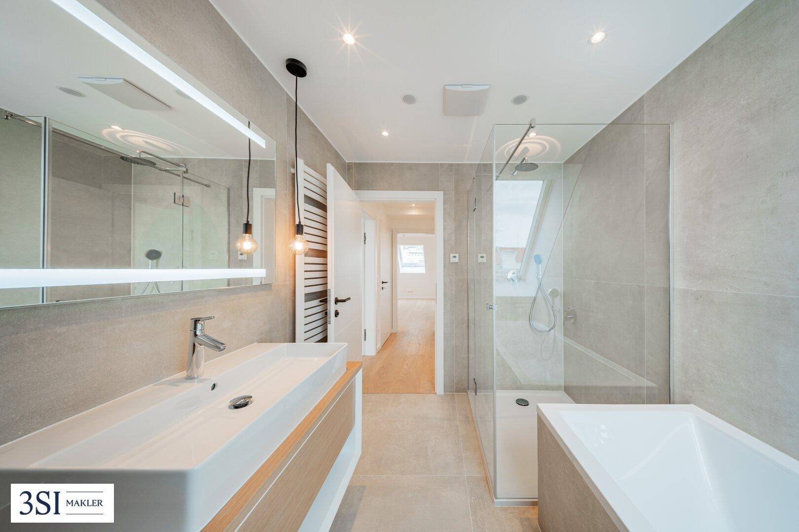 Modernes Badezimmer mit großem Waschtisch, begehbarer Dusche und Badewanne.