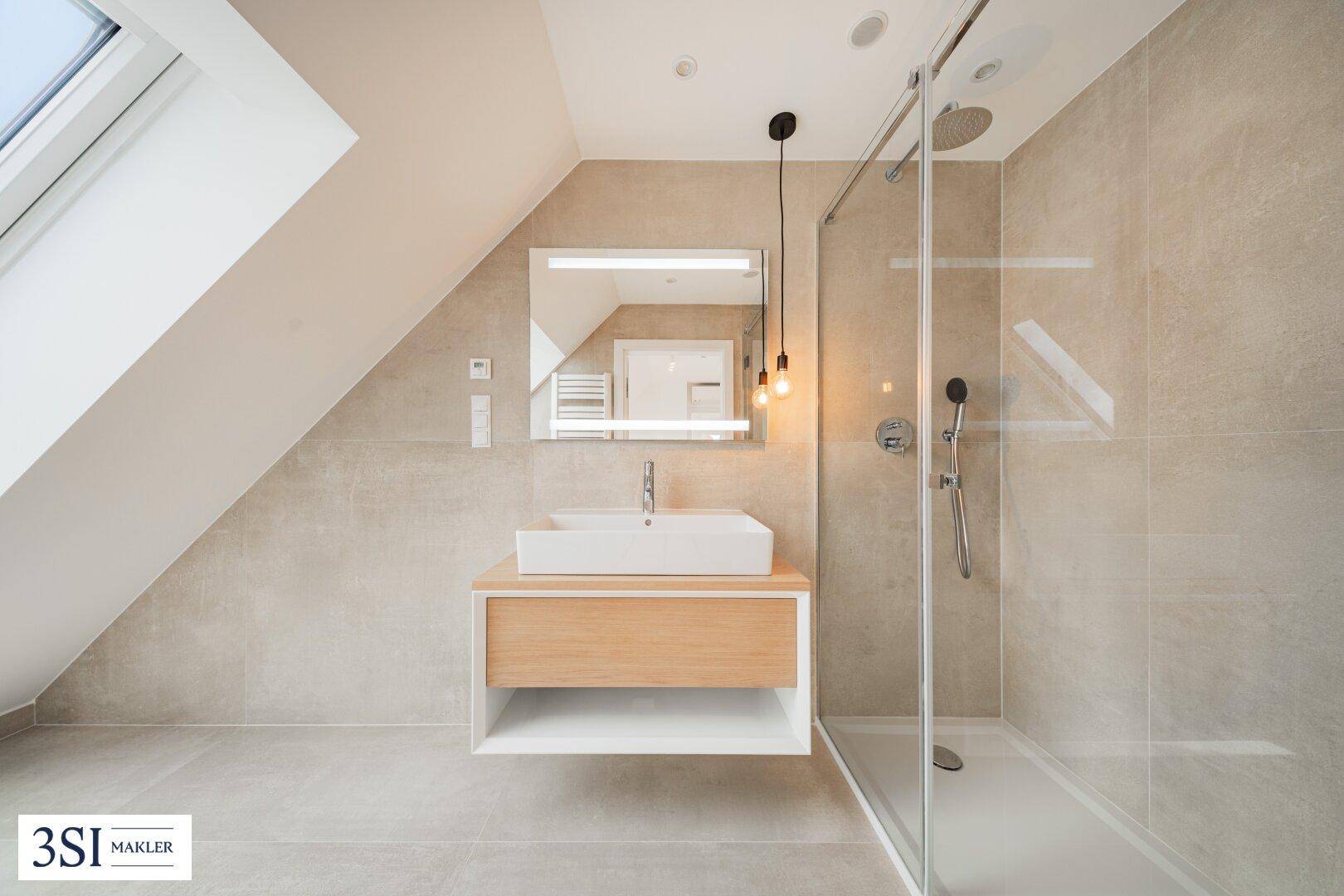 Modernes Badezimmer mit begehbarer Dusche, Einzelwaschbecken und Dachschräge, hell gefliest.