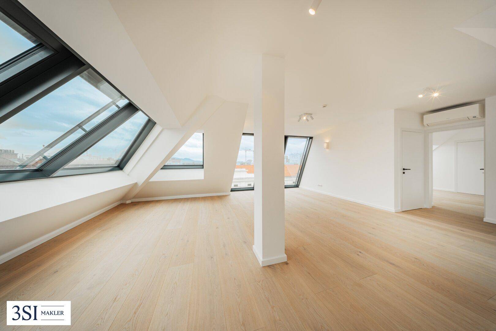Leeres Wohnzimmer mit Holzboden, großen Fenstern und Klimaanlage, bereit zur individuellen Gestaltung.