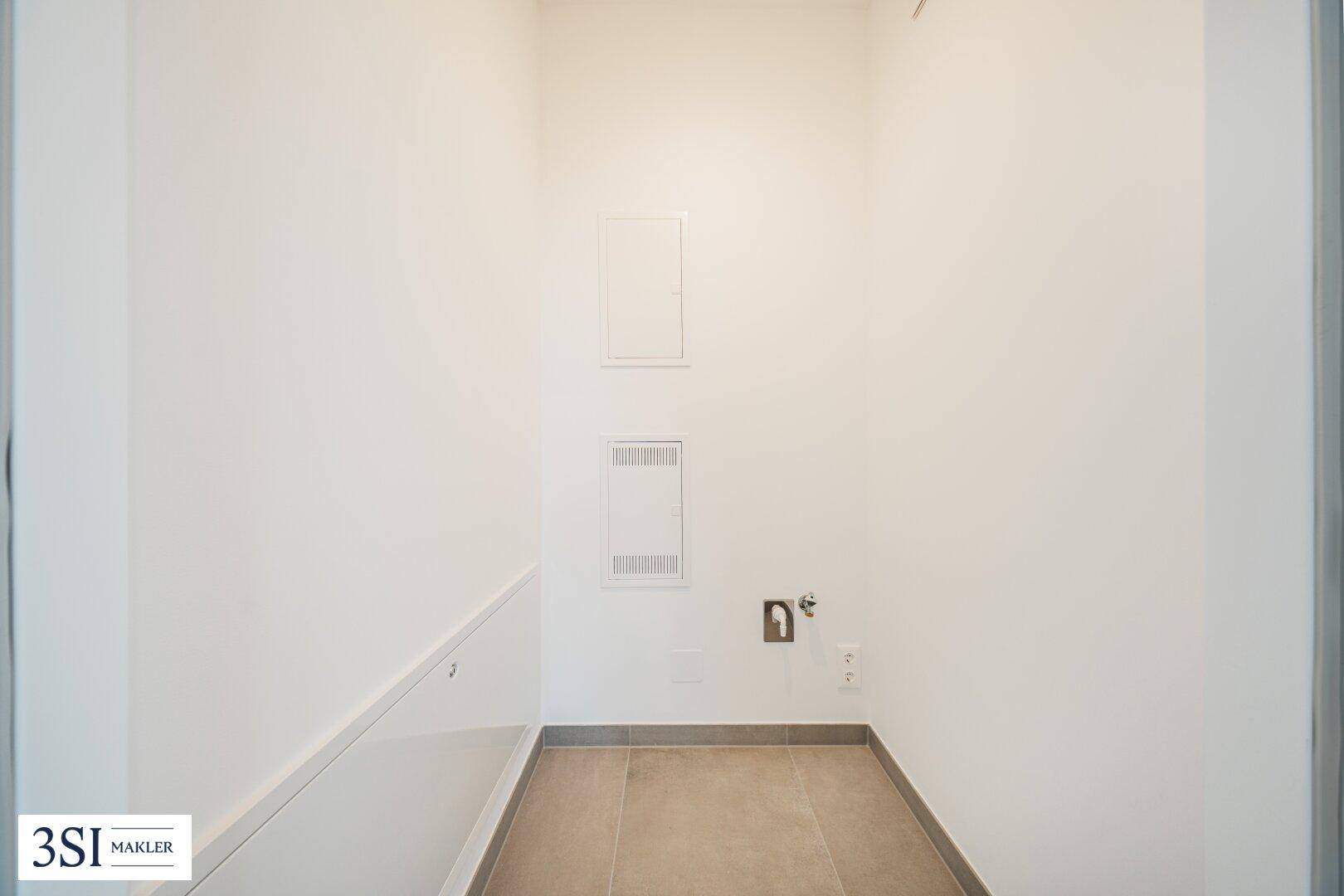 Praktischer Hauswirtschaftsraum mit Fliesenboden und Anschlüssen für Waschmaschine.