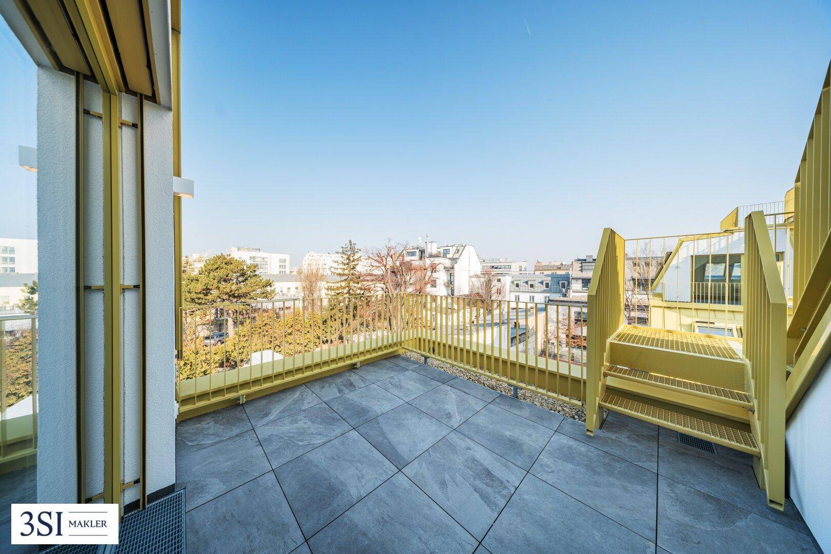 Große Dachterrasse mit Fliesenboden und gelbem Geländer, bietet einen weiten Blick.