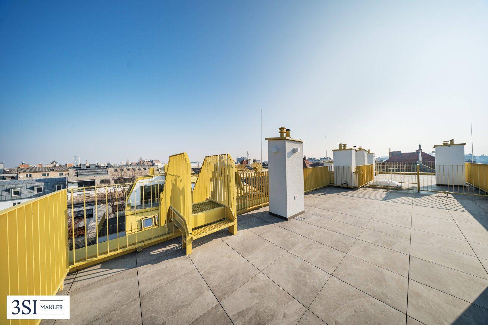 Geräumige Dachterrasse mit gelbem Geländer und Treppe, ideal für Entspannung im Freien.