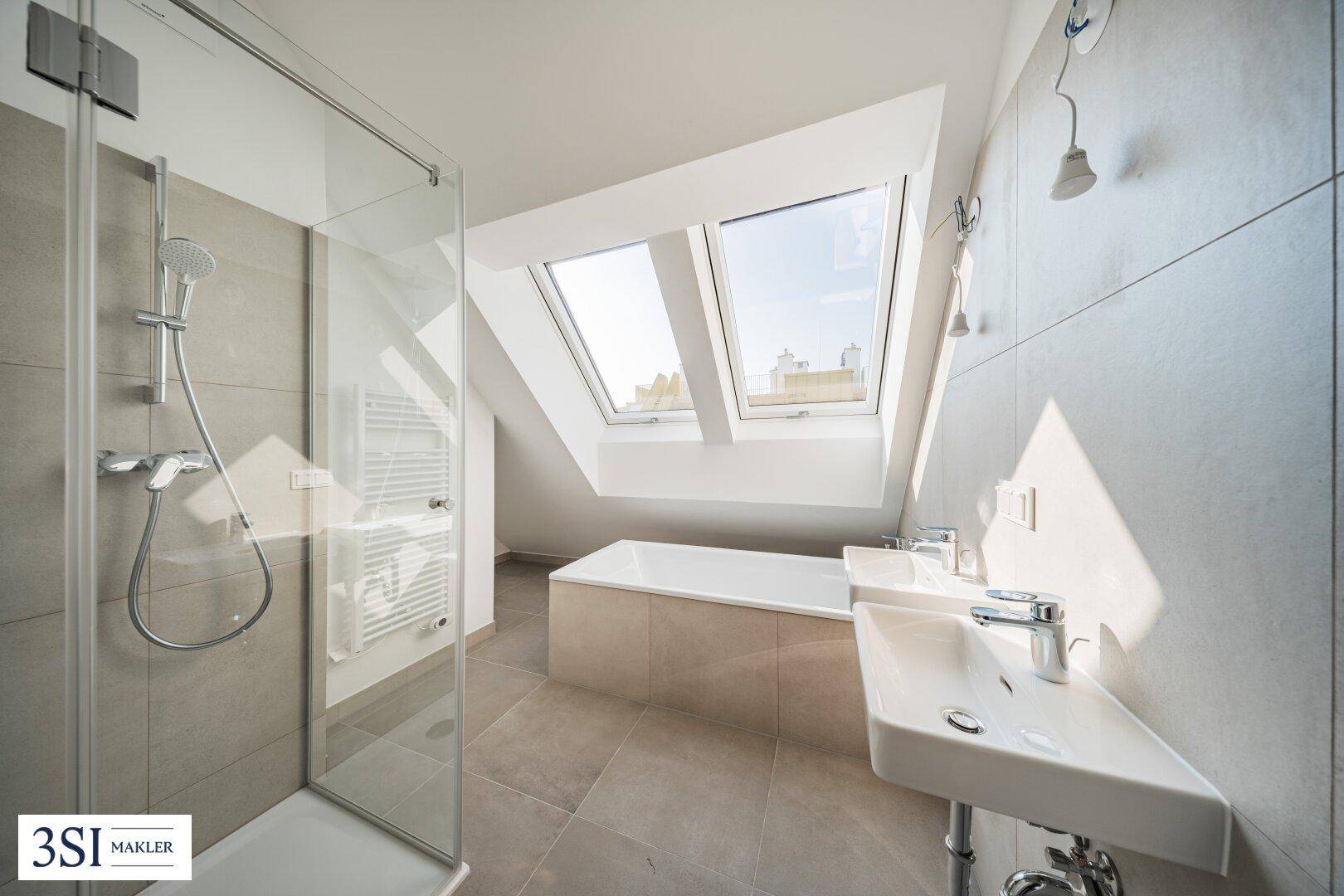 Modernes Badezimmer mit Dusche, Badewanne, Doppelwaschbecken und Dachfenstern.