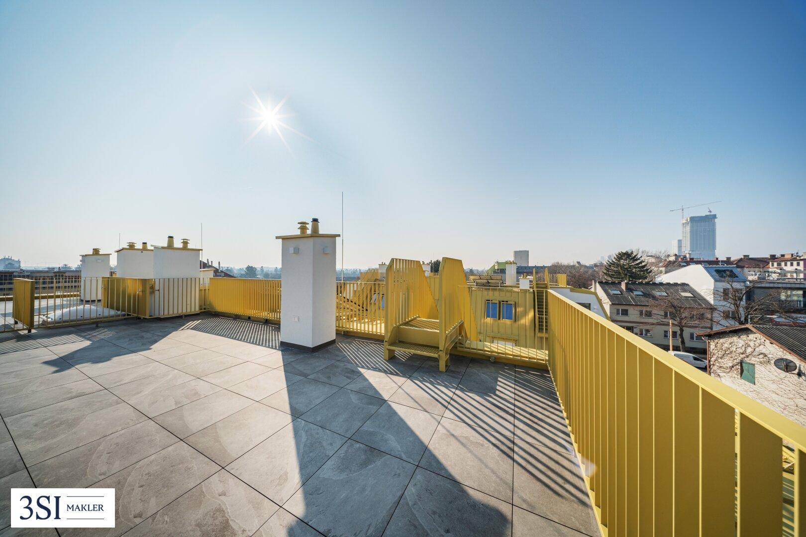 Sonnige Dachterrasse mit weitem Stadtblick und gelben Designelementen.