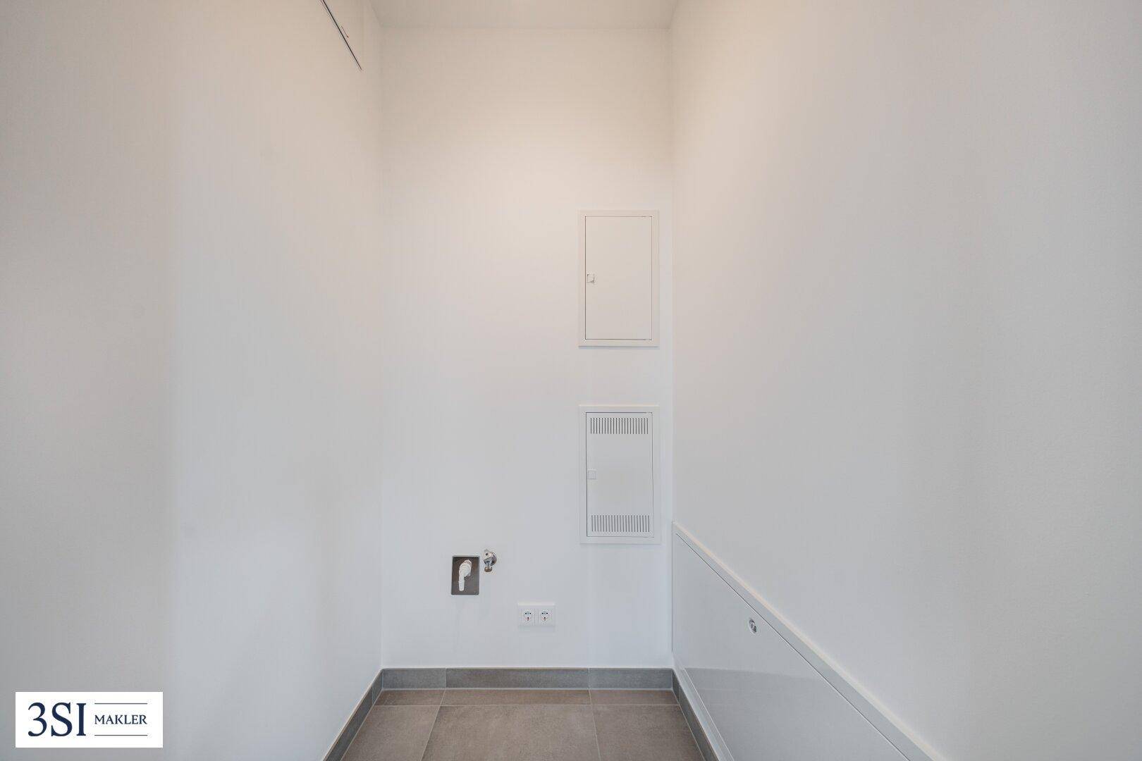 Kleiner Hauswirtschaftsraum mit Fliesenboden und Anschlüssen für Geräte.