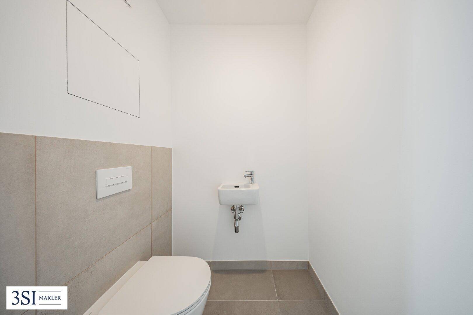 Modernes Gäste-WC mit wandhängender Toilette und kleinem Waschbecken.