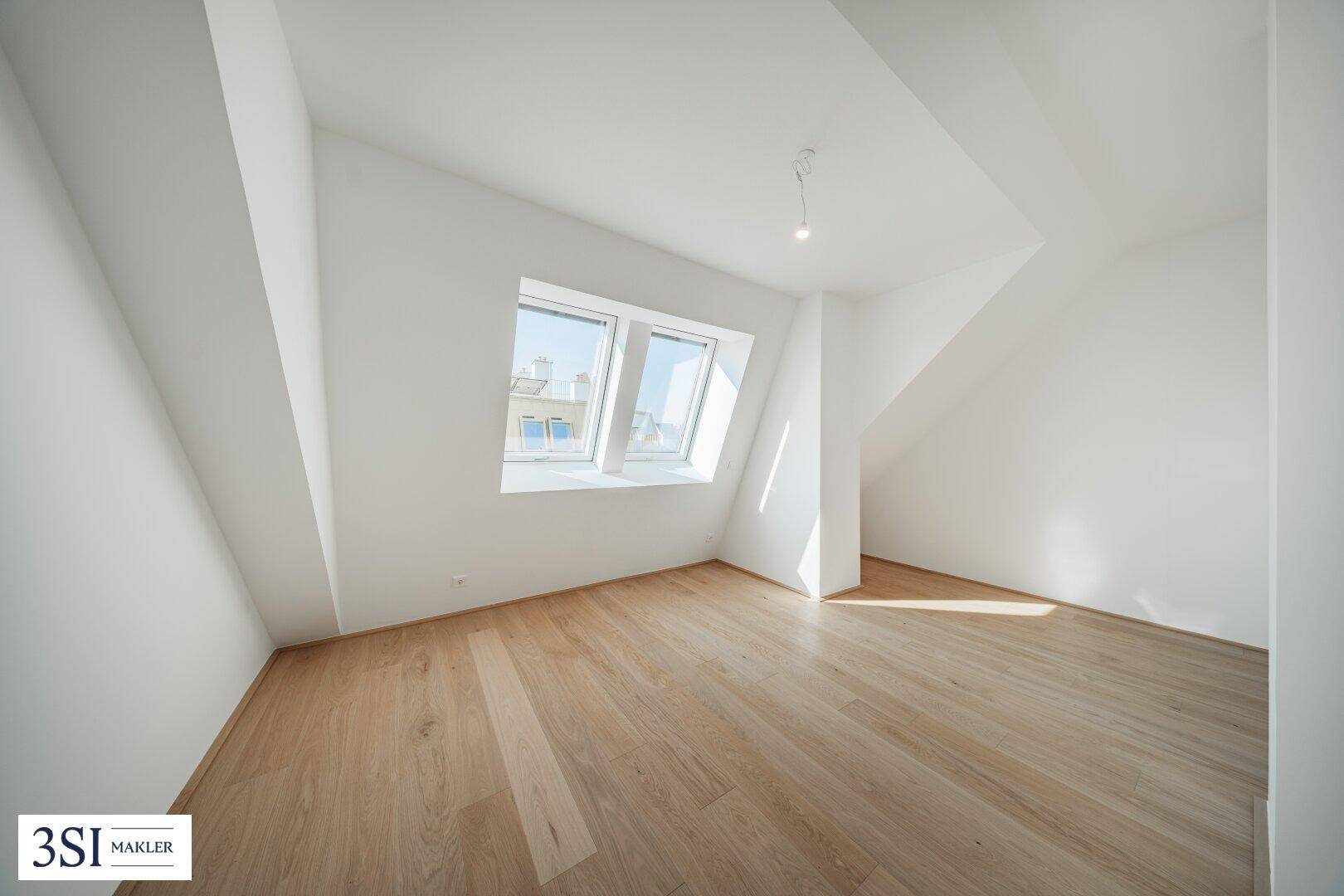 Helles Schlafzimmer mit Holzboden, schrägen Wänden und einem Fenster mit Stadtblick.