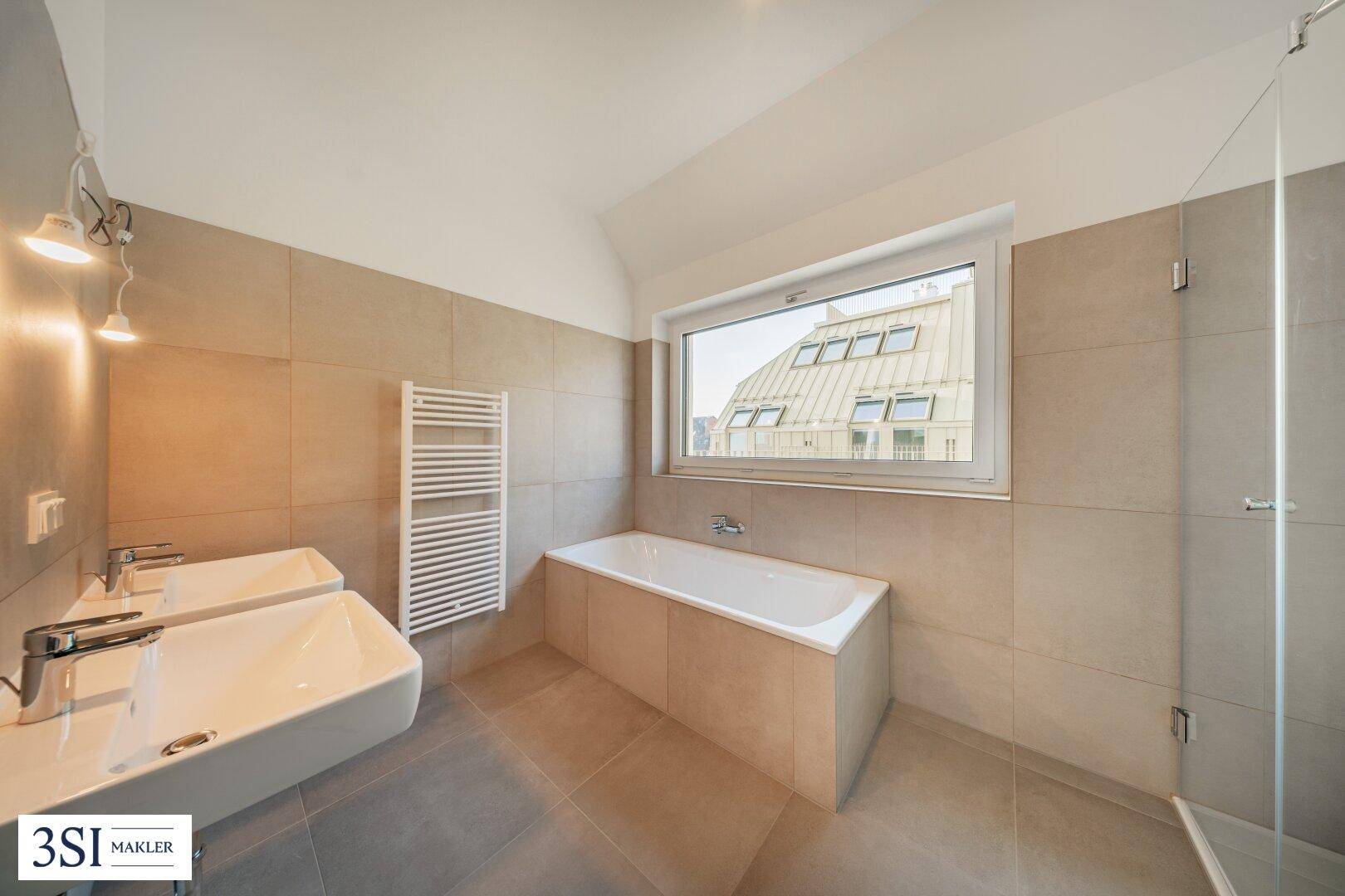 Modernes Badezimmer mit Doppelwaschbecken, Badewanne, Dusche und Fenster.