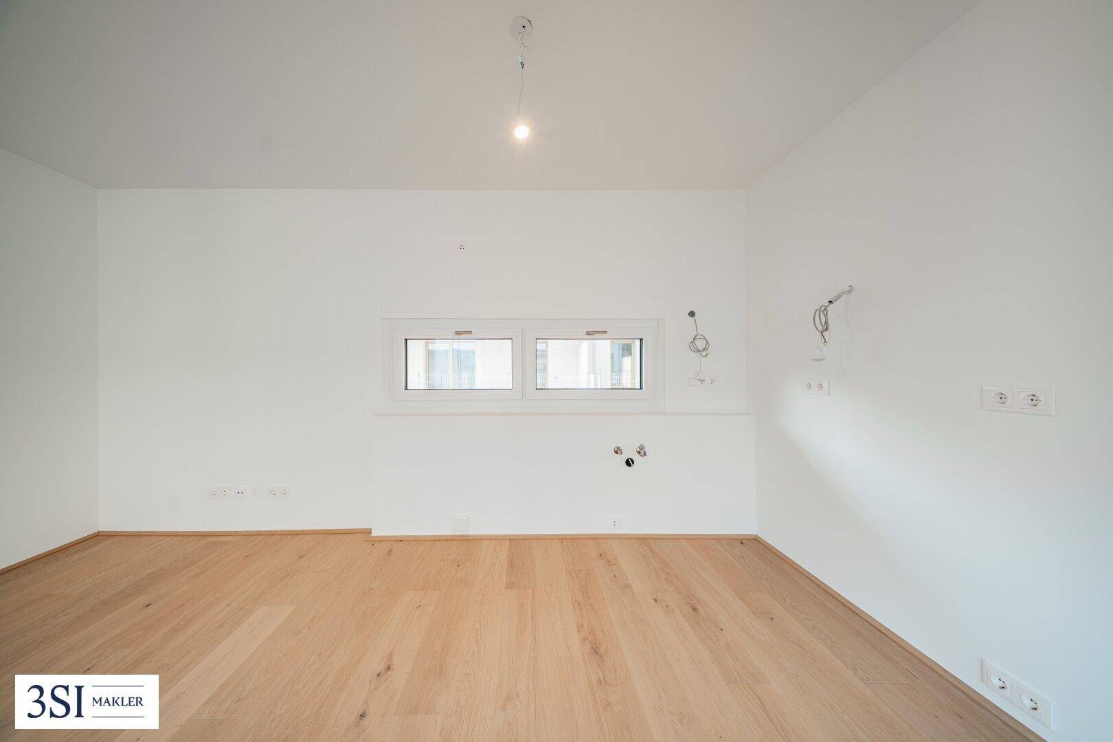 Leerer Raum mit Holzboden und kleineren Fenstern, bietet flexible Nutzungsmöglichkeiten.