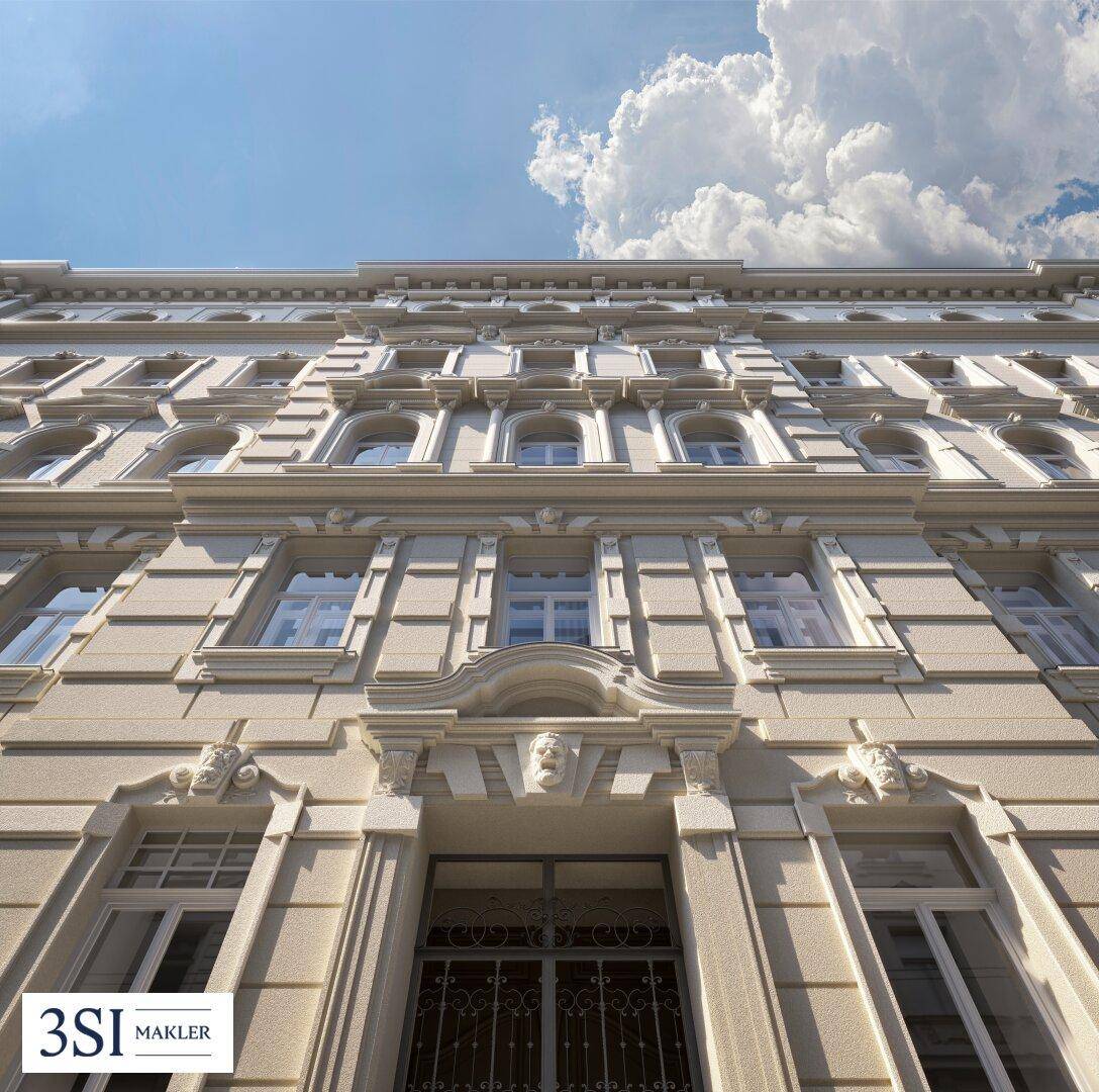 Historische Fassade eines eleganten Gebäudes mit vielen Fenstern und Stuckverzierungen unter blauem Himmel.