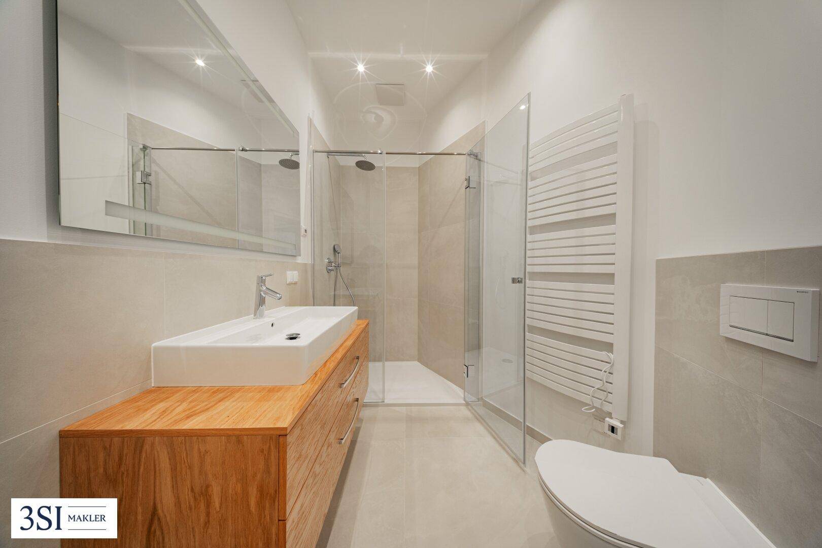 Modernes Badezimmer mit begehbarer Dusche, Holzwaschtisch und beheiztem Handtuchhalter.