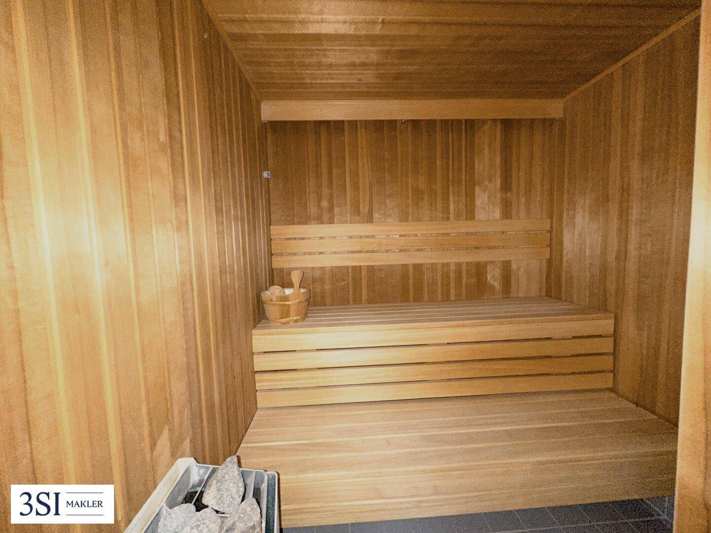 Gemütliche Holzsauna mit Bänken und traditionellem Saunaofen für Entspannung.