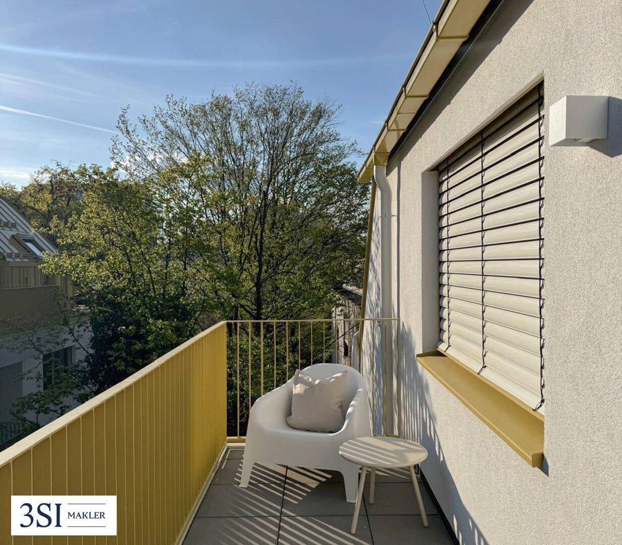 Heller Balkon mit gelbem Geländer und moderner Sitzgelegenheit, ideal für entspannte Stunden im Freien.