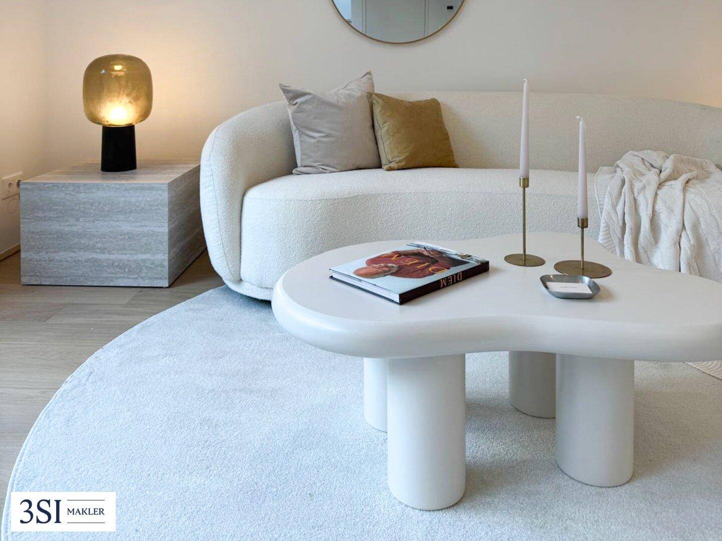 Detailaufnahme des modernen Wohnbereichs mit stilvollem Sofa, Couchtisch und Teppich.