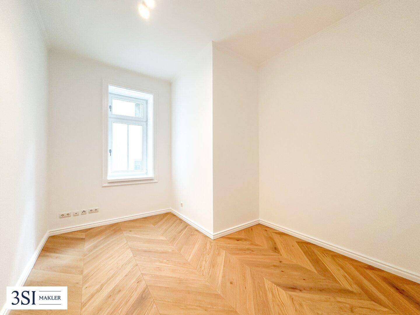 Kleines, helles Zimmer mit Fischgrätparkett und einem Fenster, vielseitig nutzbar.