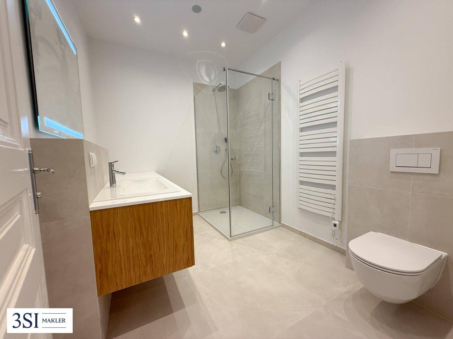 Modernes Badezimmer mit begehbarer Dusche, Hänge-WC und beheiztem Handtuchhalter.