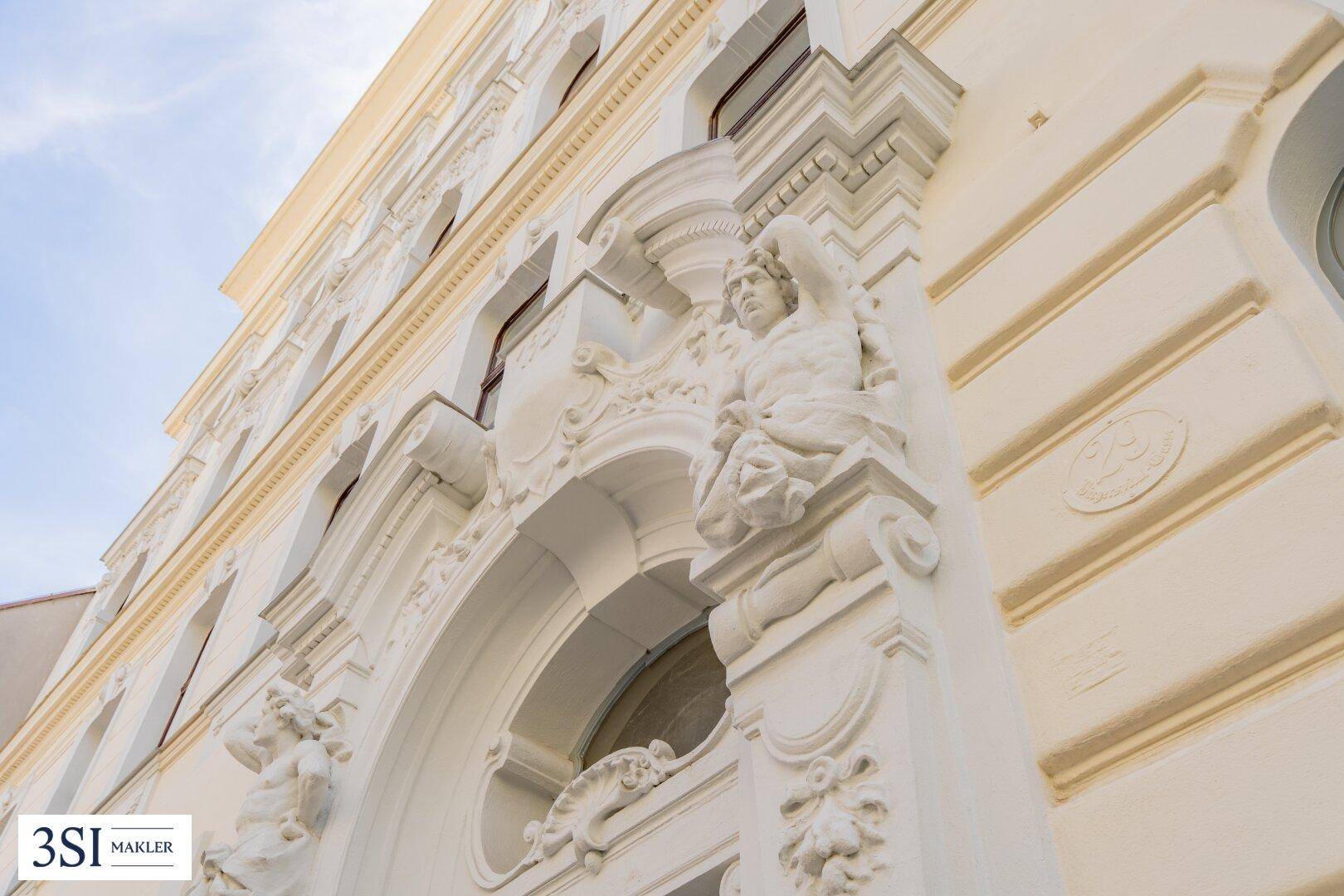 Detaillierte Stuckverzierungen und Skulpturen schmücken die Fassade des historischen Gebäudes.