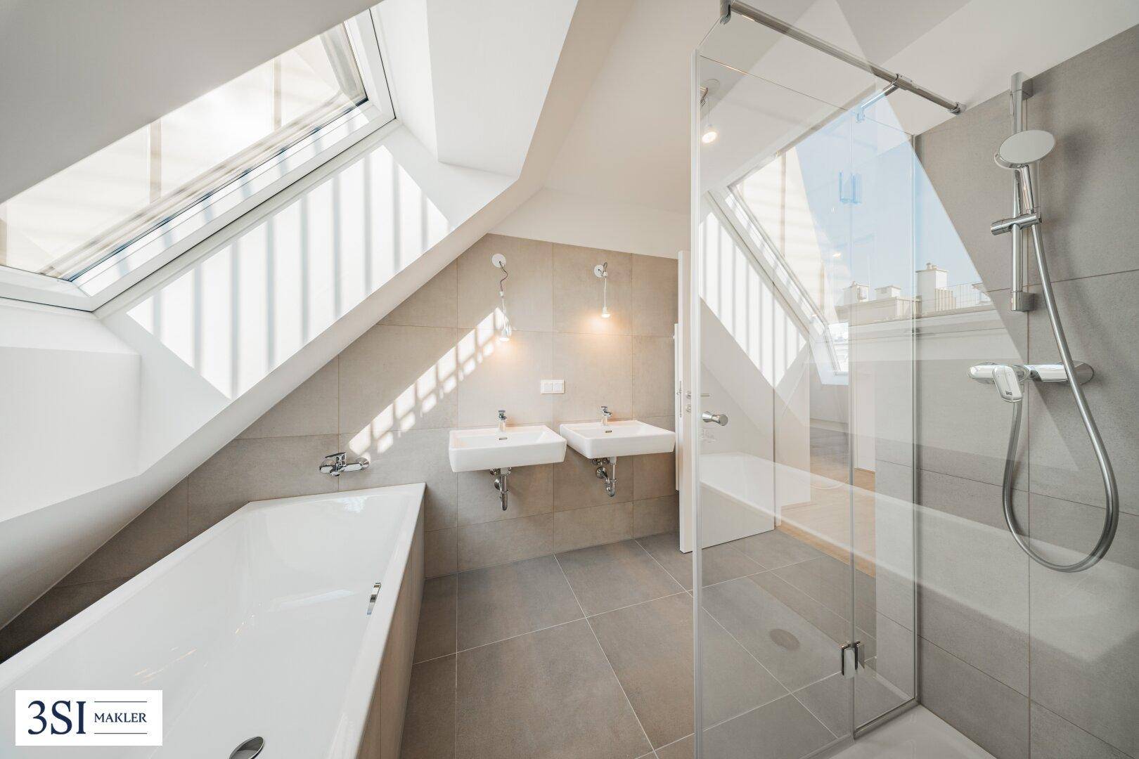 Modernes Badezimmer im Dachgeschoss mit Dachfenstern, Doppelwaschbecken, Badewanne und Dusche.