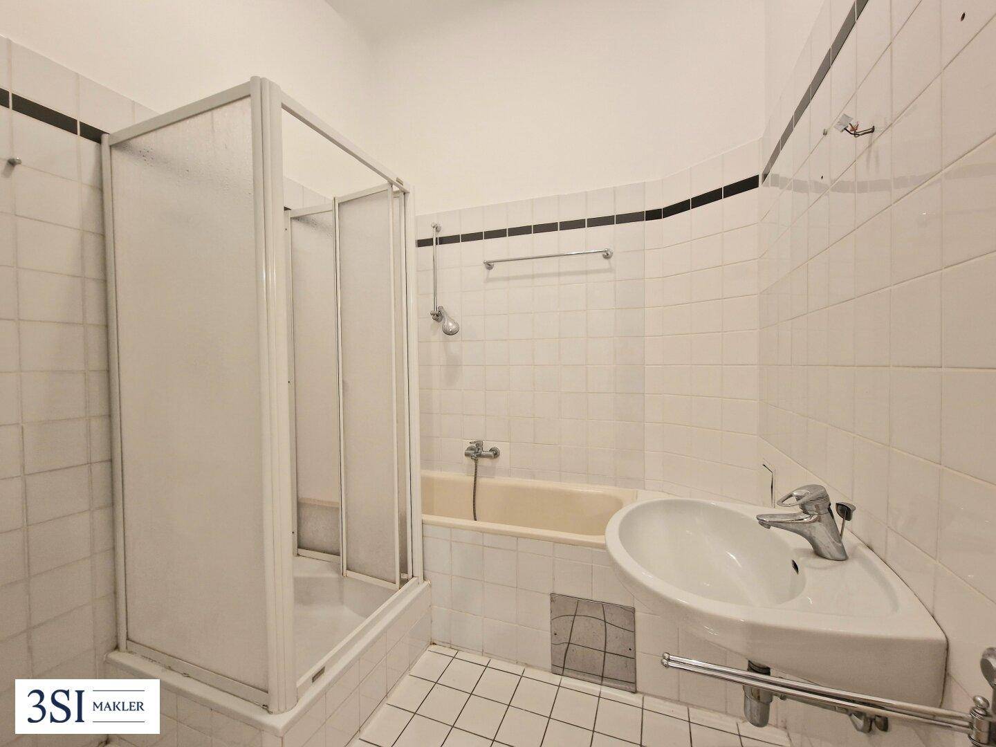 Funktionales Badezimmer mit Badewanne, Duschkabine und weiß gefliesten Wänden.