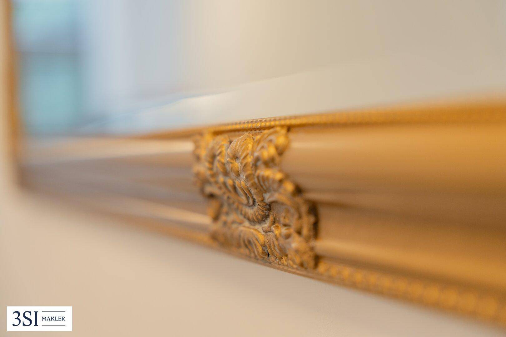 Detailaufnahme eines reich verzierten goldenen Spiegels, der Eleganz verleiht.