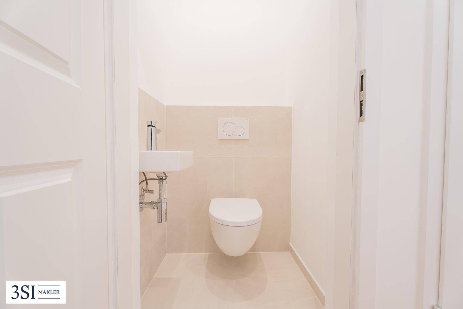 Modernes Gäste-WC mit wandhängender Toilette und kleinem Waschbecken in hellem Design.