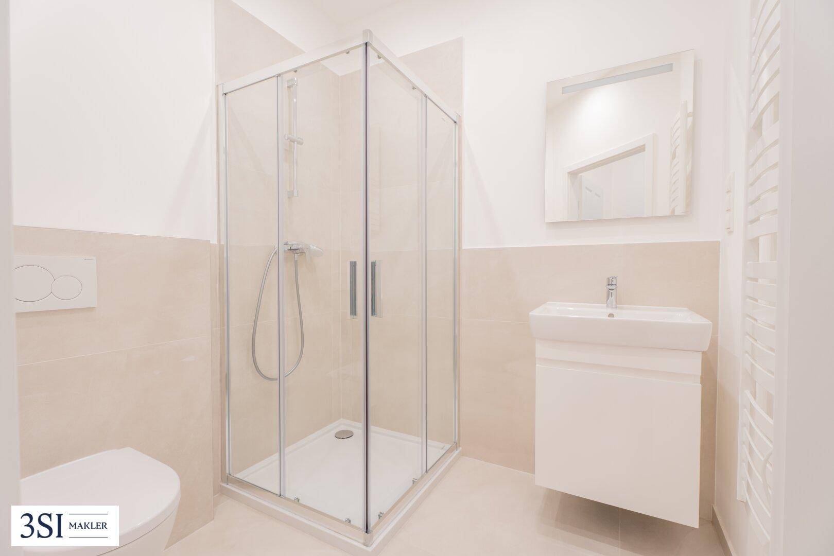 Funktionales Badezimmer mit Duschkabine, Waschbecken und wandhängendem WC.