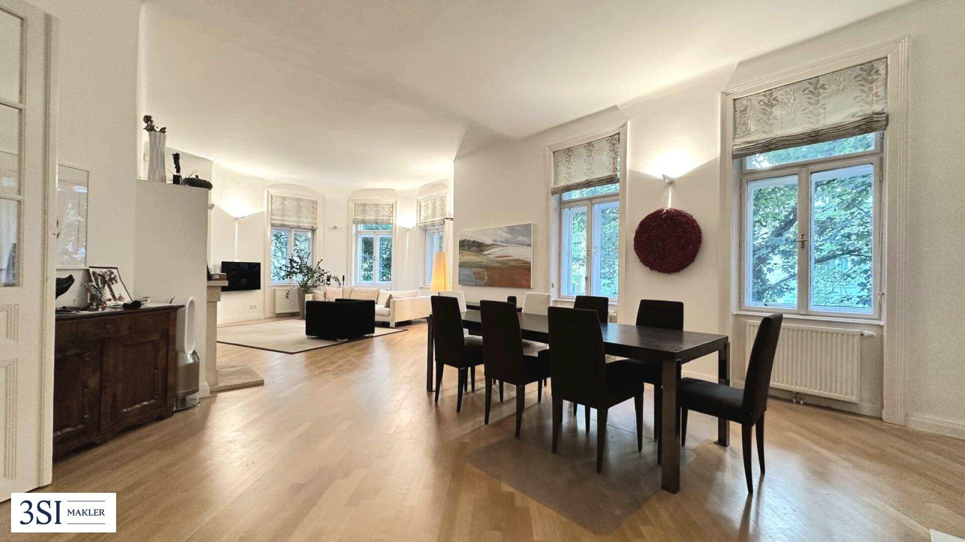 Geräumiger Wohn-Essbereich mit Holzboden, großem Esstisch und Blick ins Grüne.