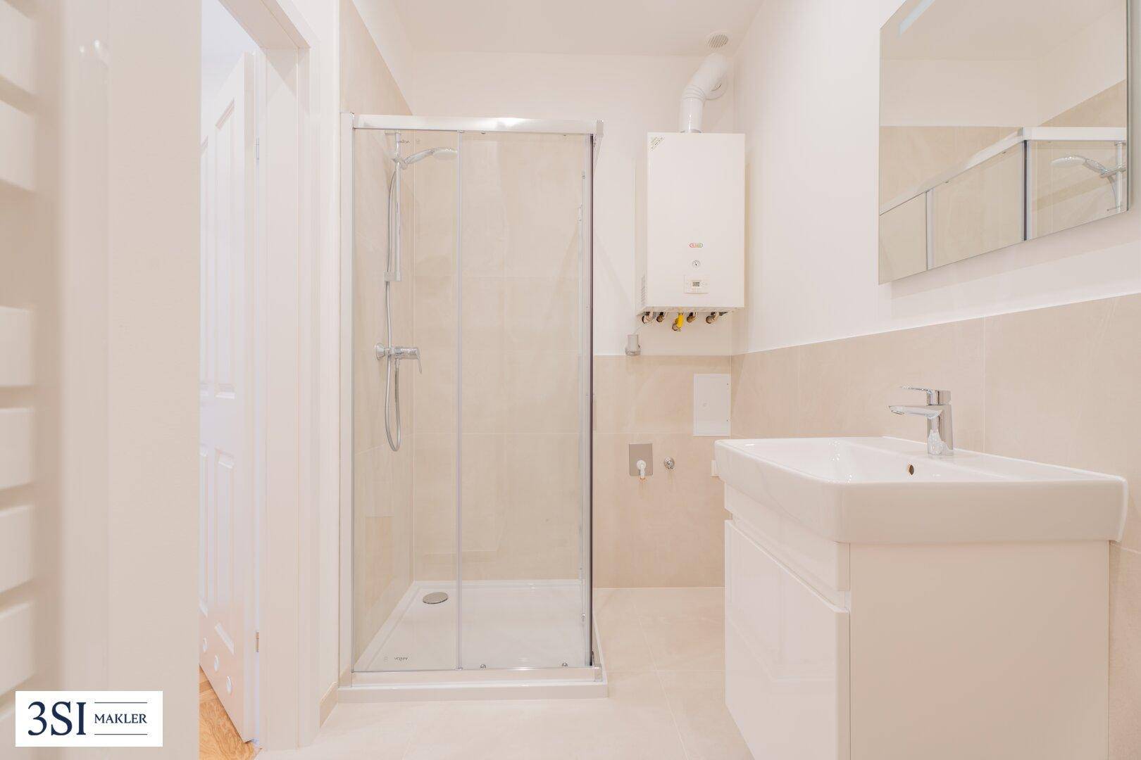 Modernes Badezimmer mit Duschkabine, Einzelwaschbecken und beigefarbenen Fliesen.