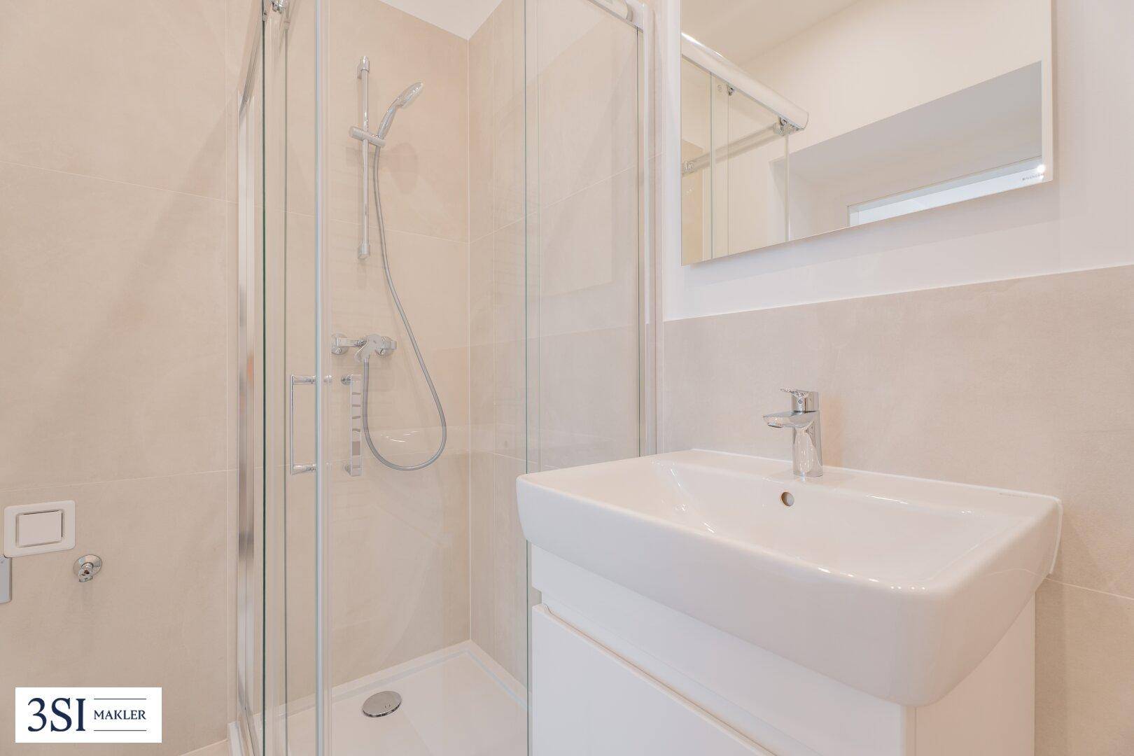 Modernes Badezimmer mit Duschkabine, Waschbecken und Spiegelschrank.