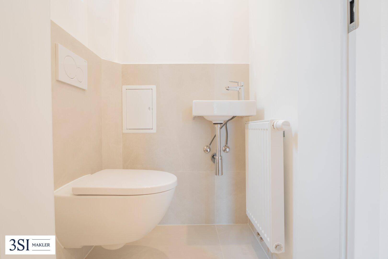 Modernes Gäste-WC mit wandhängender Toilette und kleinem Waschbecken.
